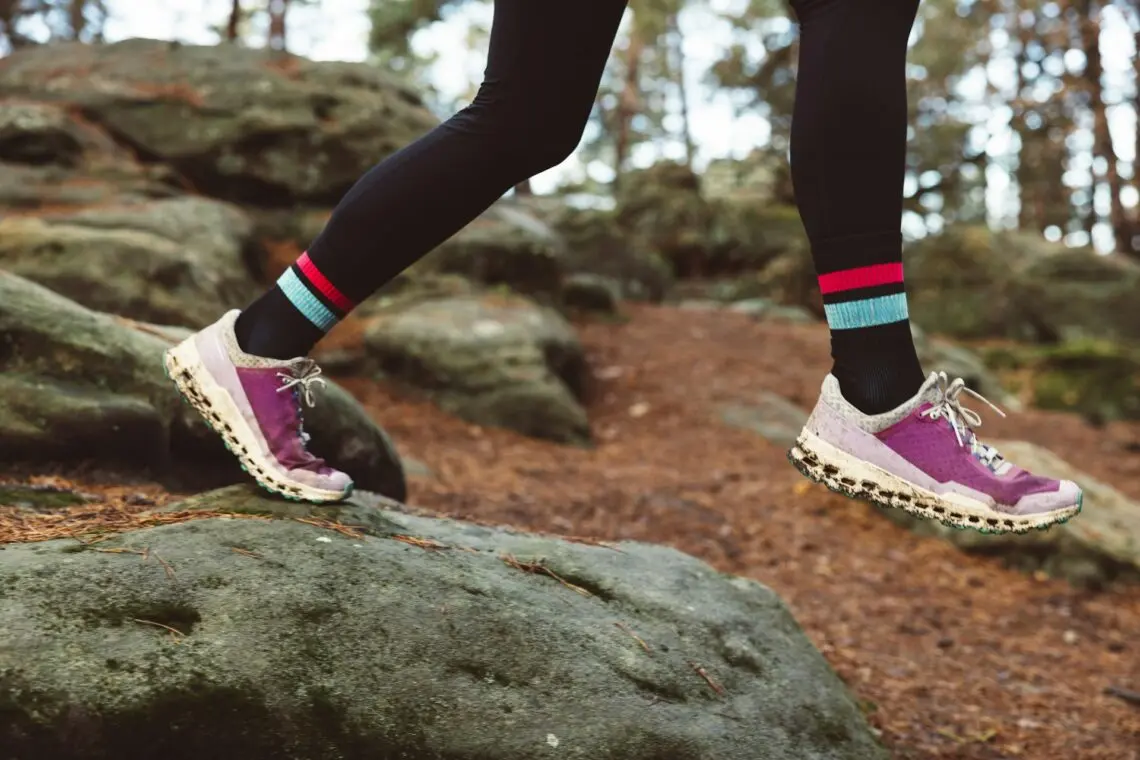 Jambes de traileuse, chaussettes de trail sur un sentier rocheux